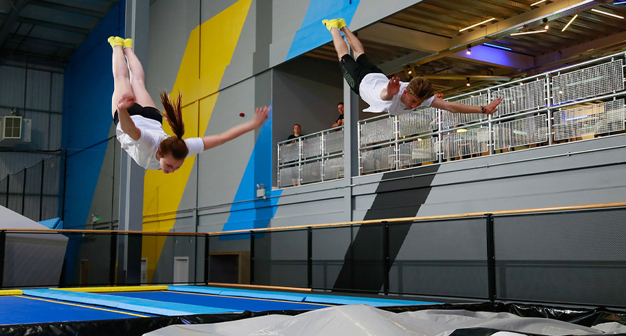 people performing in a trampoline park