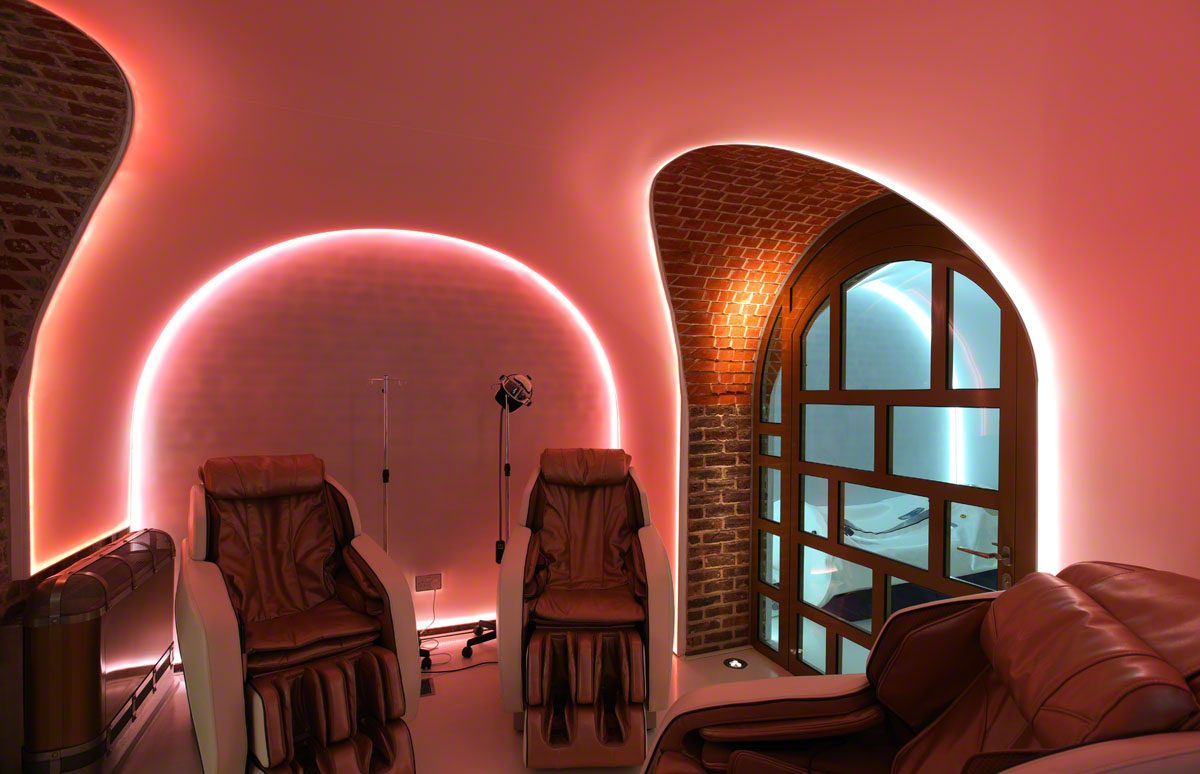 massage chairs in a red lit spa room