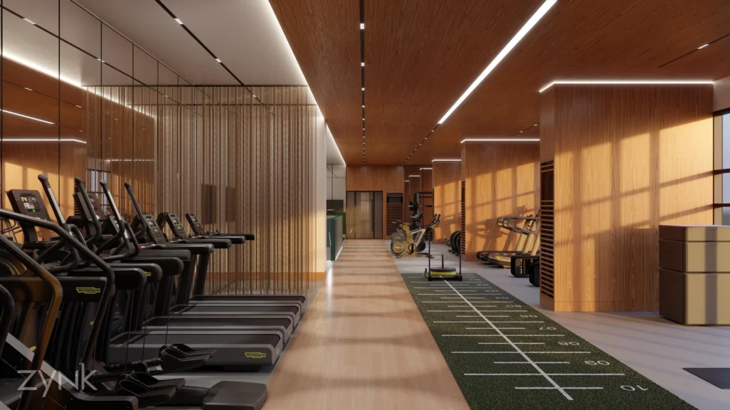 Gym area with a wooden ceiling, featuring cardio equipment including steppers, treadmills, bikes, and a sled push along a grass track.