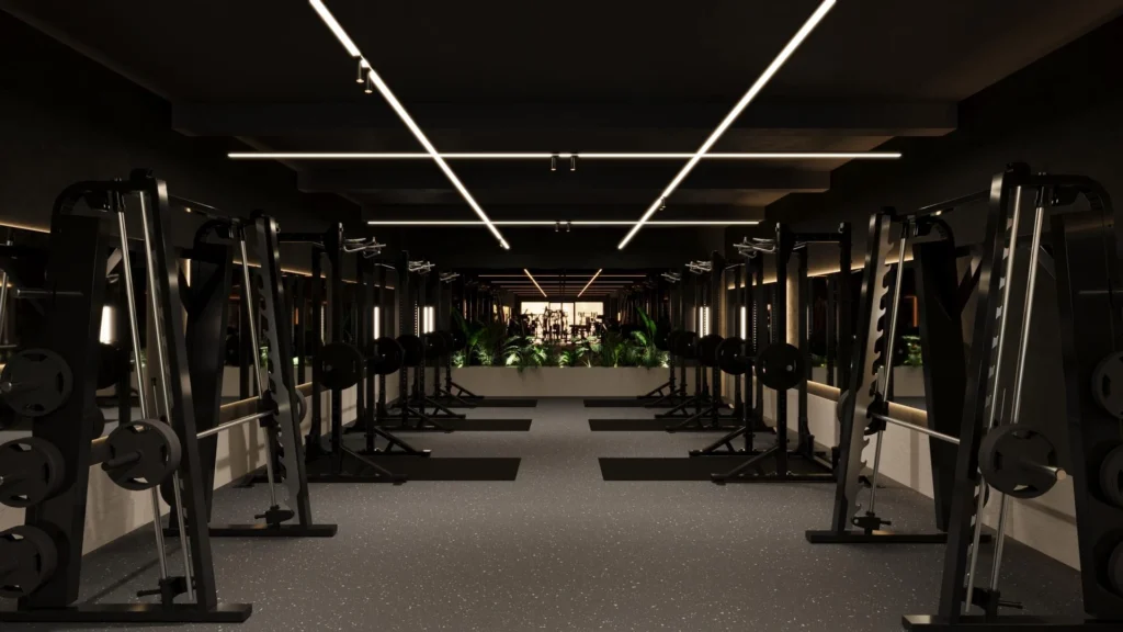 Two rows of squat racks and mats in a low-lit dark grey room with mirrored walls and feature strips of white lighting, creating a sleek and modern training space.